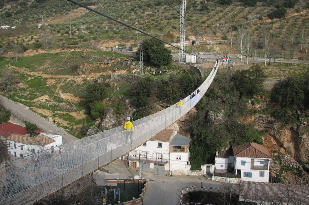 Tirolina urbana y puente colgante sobre el río Velillos en Frailes
